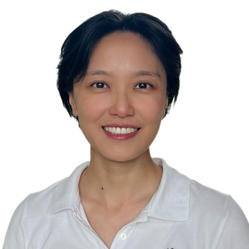 Alex's headshot. She is wearing a white shirt smiling in front of a white background